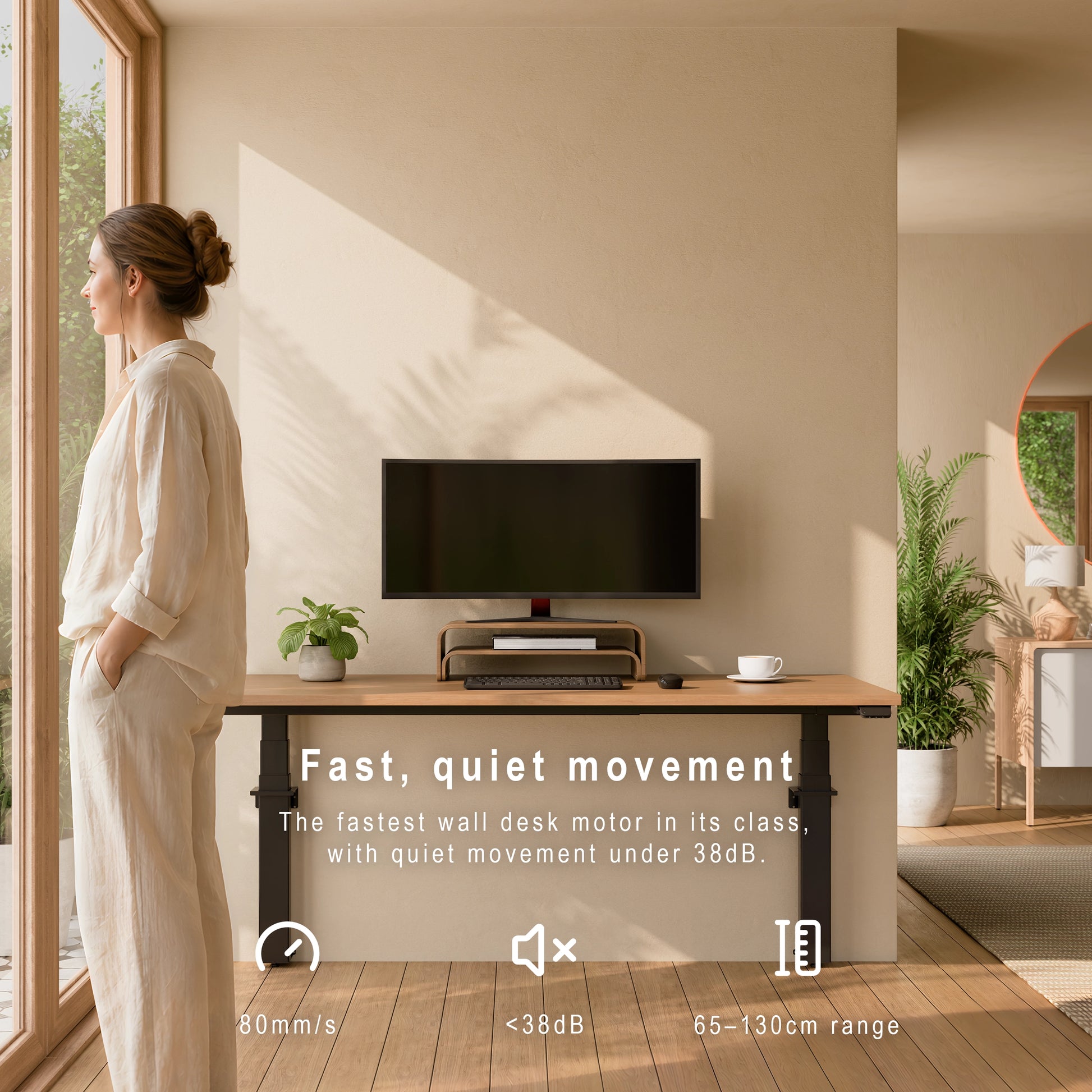 Wall-mounted height adjustable desk in a home office showing fast quiet movement and 65 to 130cm adjustment range. Woman standing at a modern desk with a computer monitor, surrounded by natural light. 