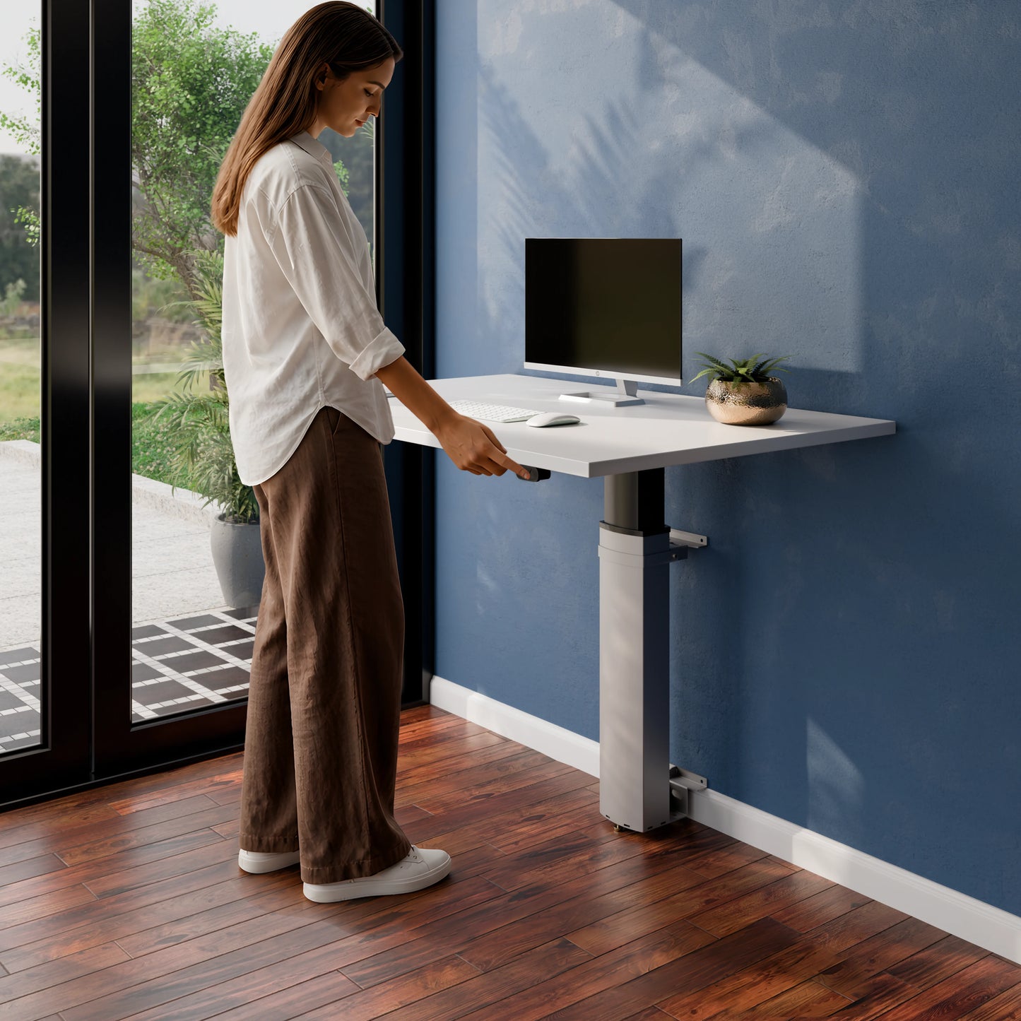 Person adjusting the ConSet 501-19 modular wall mounted standing desk in a home office