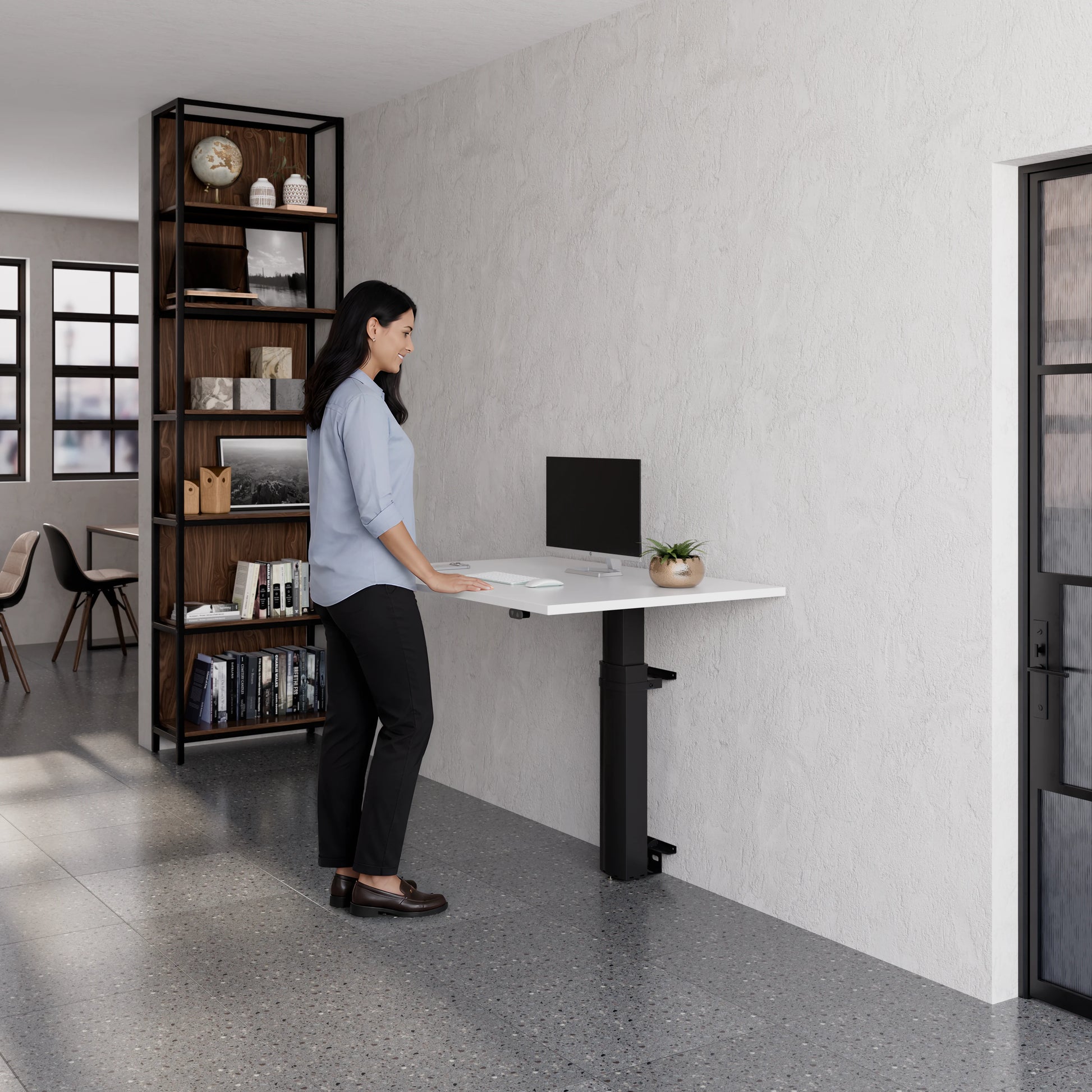 Person using the ConSet 501-19 modular wall mounted desk in a modern office setting