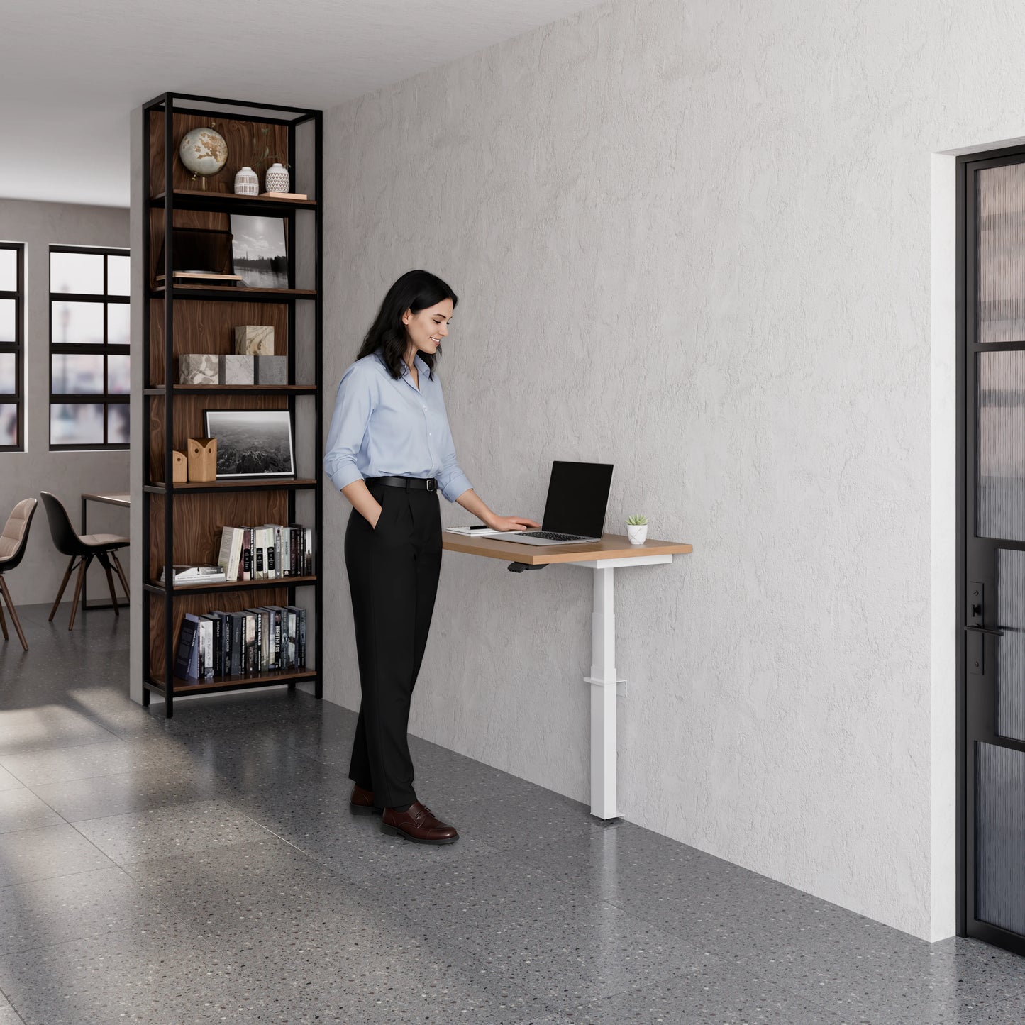 Person using the Linak Wall Solo adjustable desk with laptop in a modern office setting