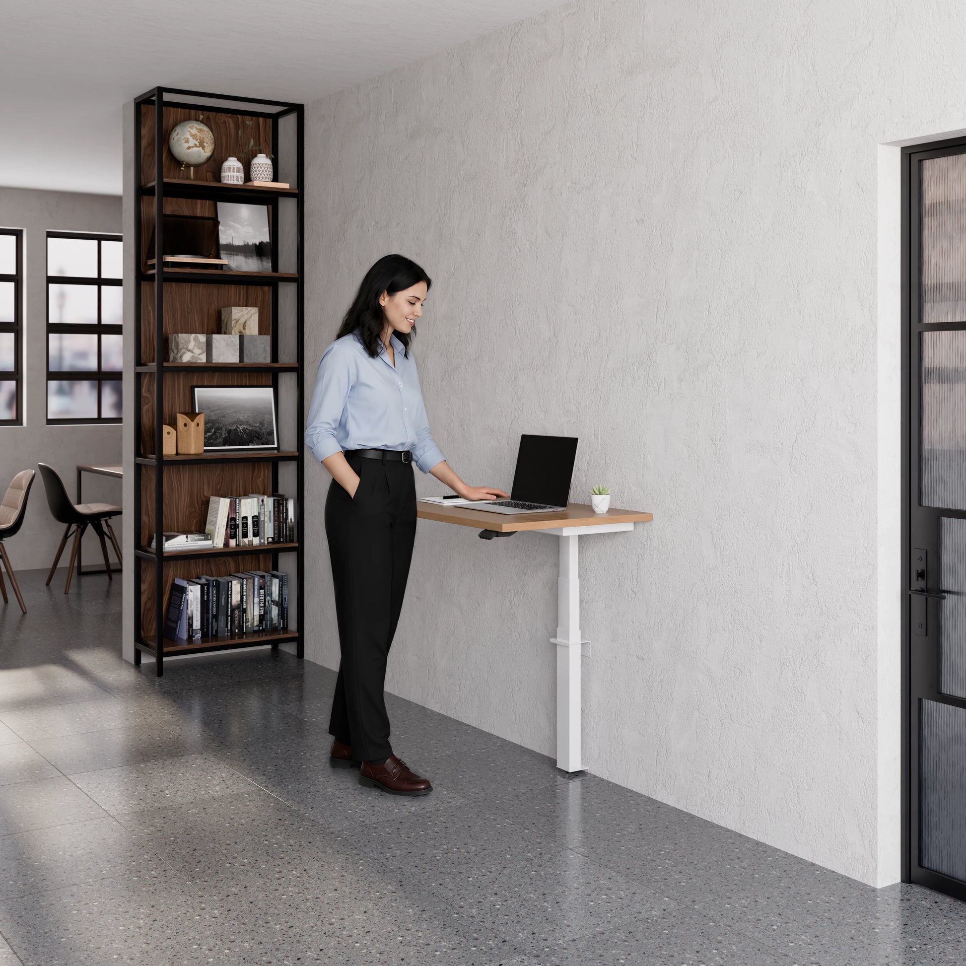 Person using the Linak Wall Solo adjustable desk with laptop in a modern office setting